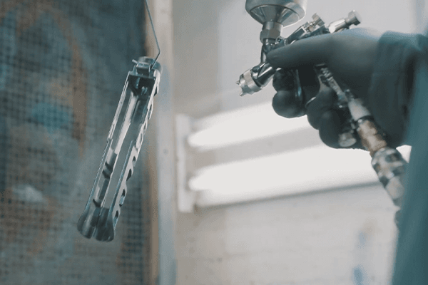 Cerakote keramisch-polymeer coating wordt aangebracht met spuitpistool